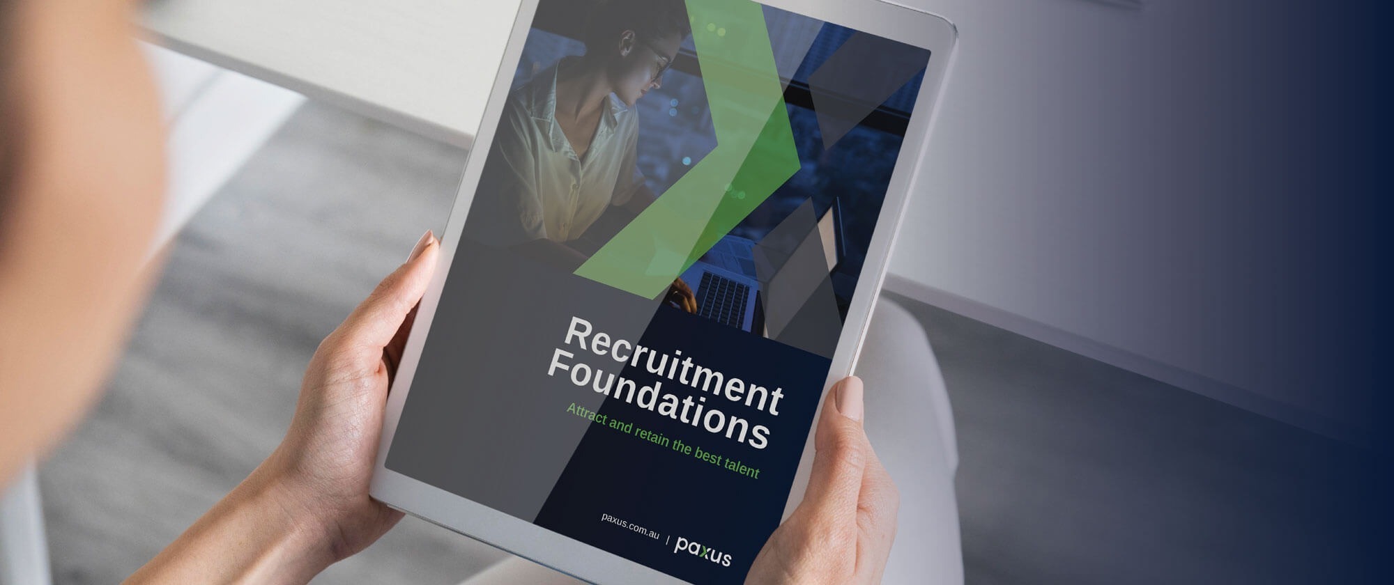 A person holding a tablet displaying a cover of an e-book titled 'recruitment foundations,' which features a professional recruitment theme.
