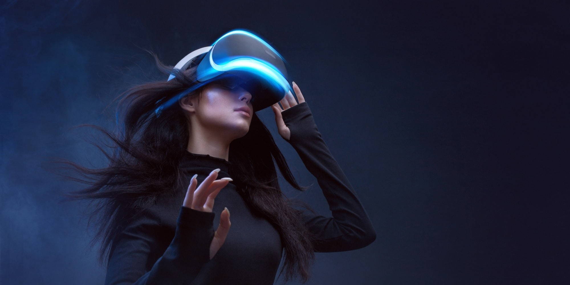 Woman immersed in a virtual reality experience, her hair flowing as she explores a digital universe.