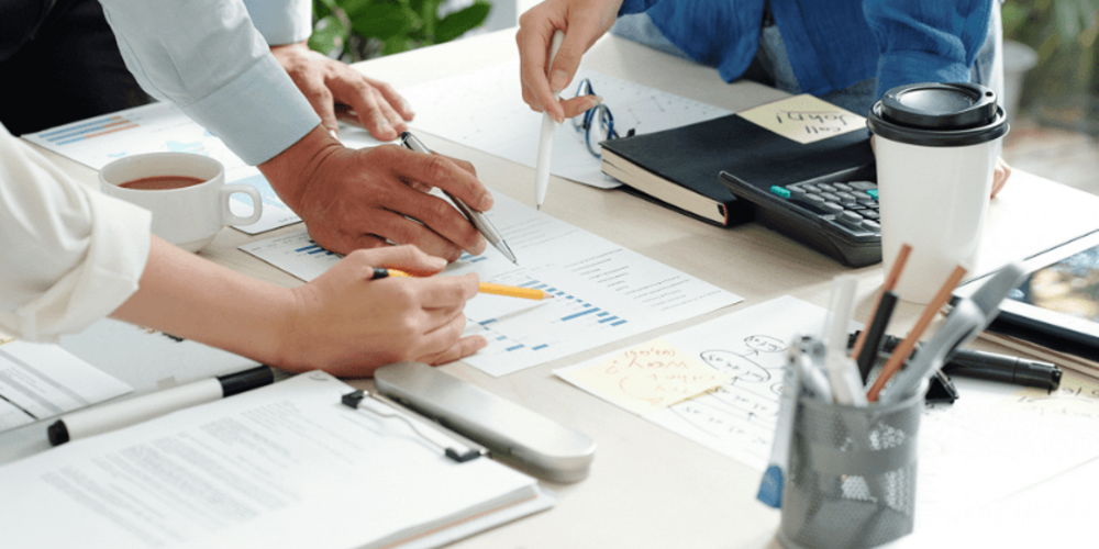 Professionals collaborating over charts and data during a business meeting.