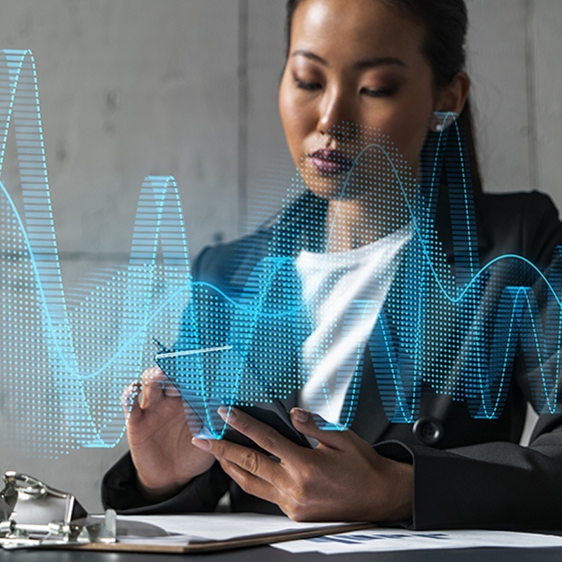 Businesswoman analyzing digital graphs and data projections on a tablet device.